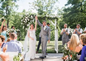 Bride and groom holding hands and raising it up together after ceremony concludes