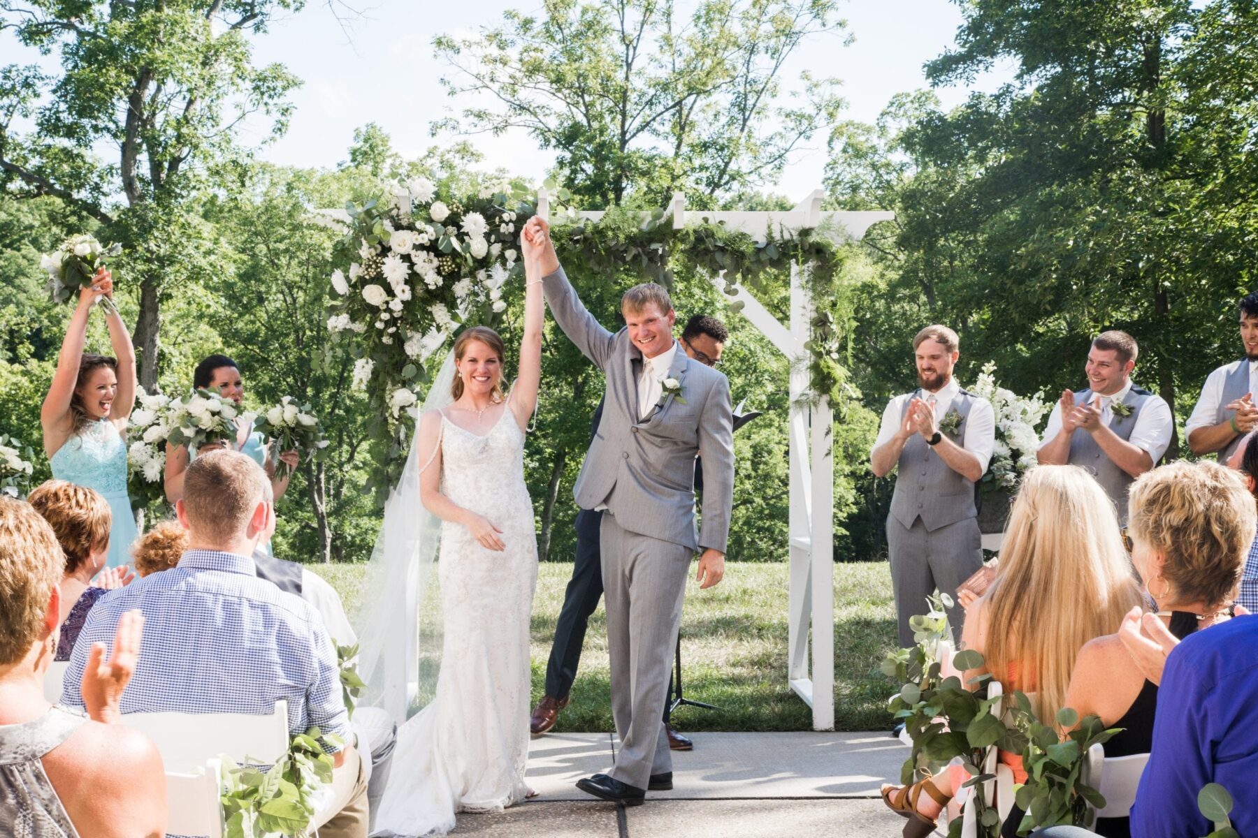 Bride and groom holding hands and raising it up together after ceremony concludes