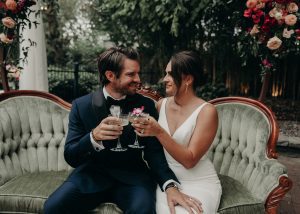 A man and woman couple cheering their drinks staring into each other's eyes