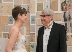 Woman in her bridal gown talking to an older gentleman