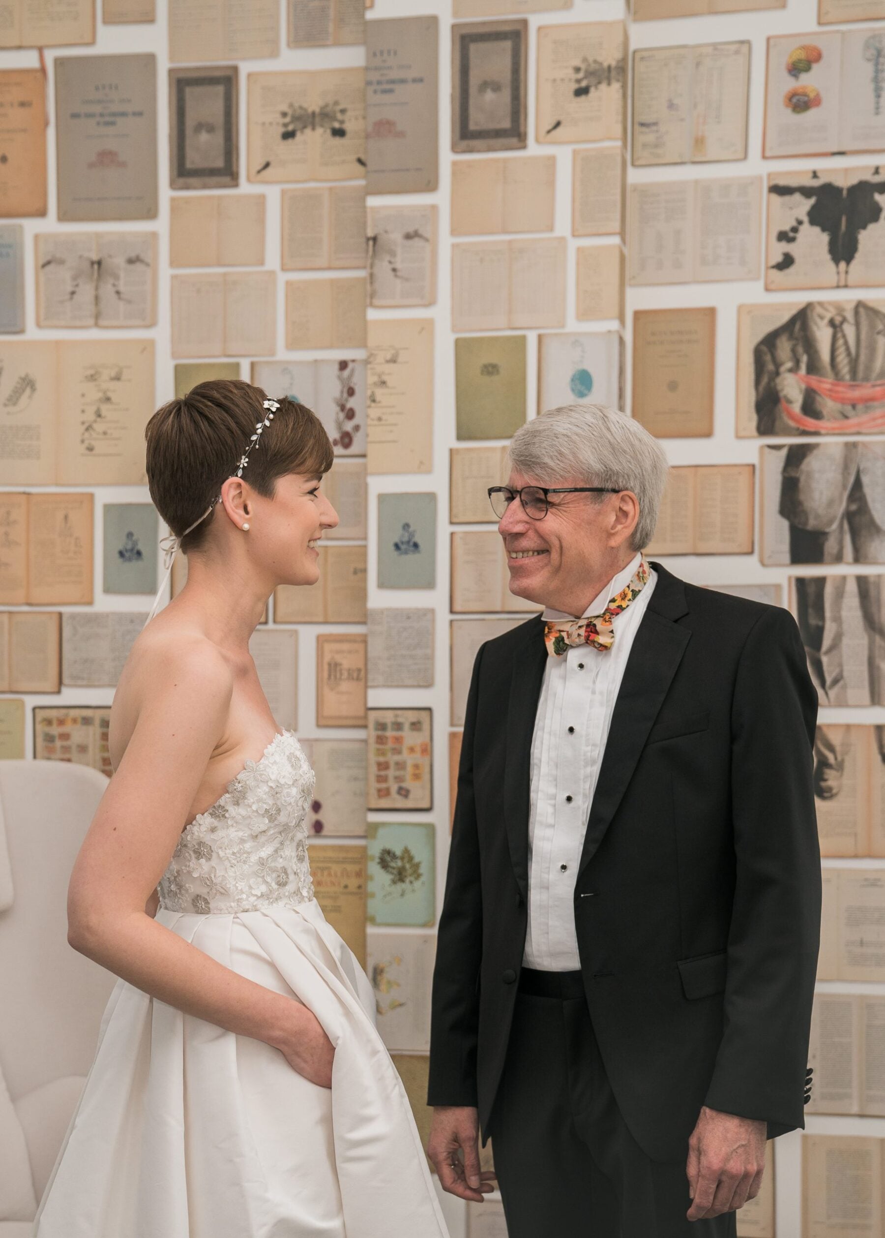 Woman in her bridal gown talking to an older gentleman